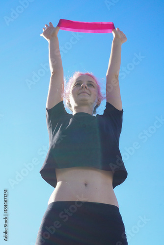 Morning outdoor fitness routine, woman training with resistance band in fresh air, simple daily exercise, active lifestyle, balance, wellness, self-care, and healthy habits.