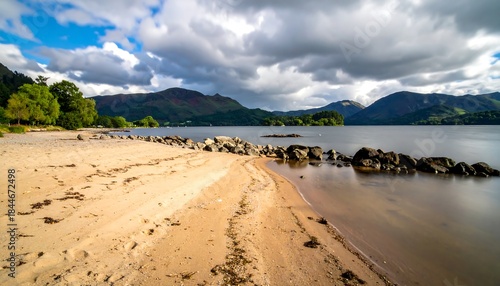 Wallpaper Mural Tranquil lake shoreline with sandy beach and distant mountains under cloudy sky Torontodigital.ca