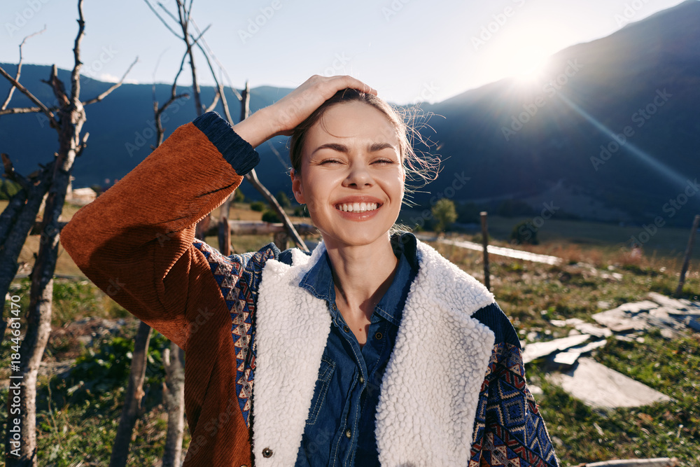 Fototapeta premium woman smile outdoor mountains sunlight portrait nature jacket, young female enjoying mountain landscape at golden hour with cozy casual outfit, candid happy expression and sun flare