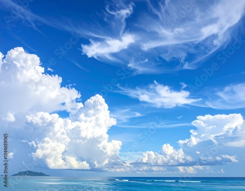 Vast blue sky filled with fluffy clouds over a tropical ocean scene