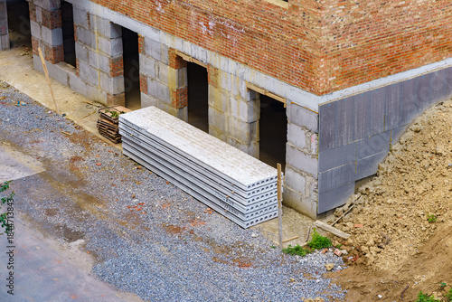 Construction site with building materials stacked near new structure in urban area