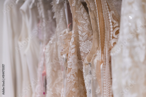 Elegant bridal gowns hanging in a fashion store showing detailed wedding dress design and refined bridal couture close up