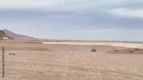 A serene desert landscape showcasing gentle sand dunes under a cloudy sky.