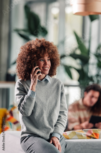 Happy woman talking on phone in modern office