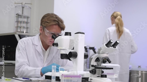 Scientists study samples using microscopes in a laboratory setting