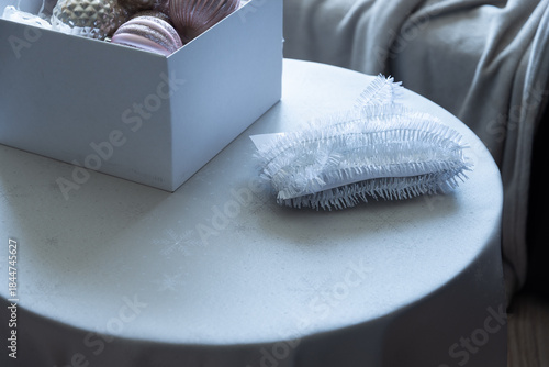 Christmas ornaments and decorative elements on round table in soft daylight