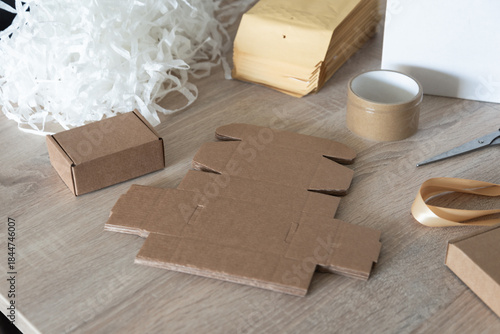Cardboard packaging blanks and packing filler on work table