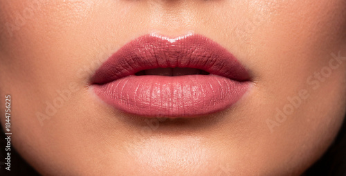 Extreme close-up of woman’s lips with flawless makeup, studio lighting