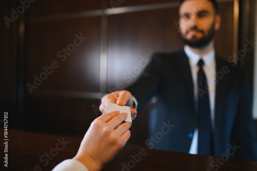 Fotografija Hotel receptionist handing key card to guest