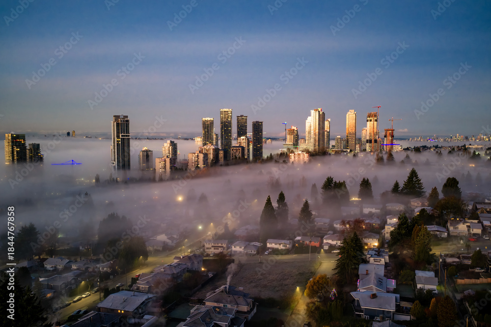Obraz premium Sunrise Over Foggy Burnaby Skyline With Tall Buildings And Residential Neighborhoods