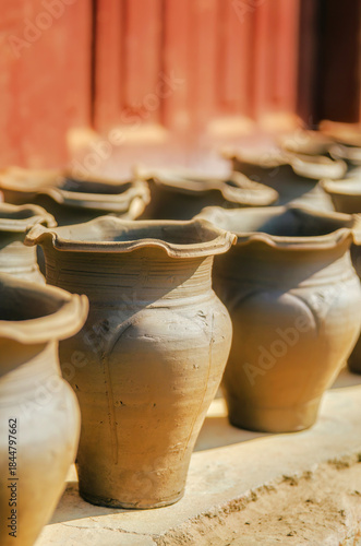 Sunlit pottery workshop displays freshly shaped clay pots