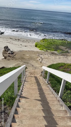 Vertical POV walking down wooden stairs toward the ocean