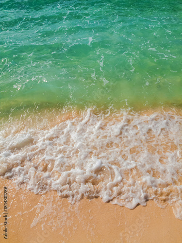 Water rolling onto a sandy shore from above