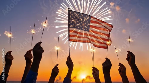 A breathtaking scene unfolds at dusk as silhouetted hands collectively raise sparkling handheld fireworks, their golden glow illuminating the vibrant twilight sky. In the foreground, a patriotic flag 