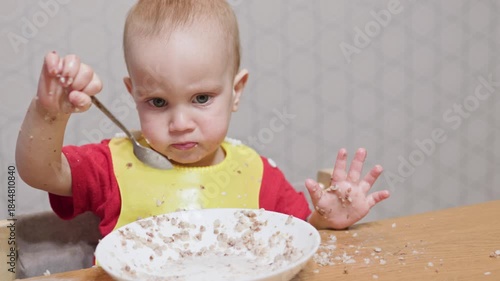 A charming and adorable baby is happily enjoying their meal, showcasing the playful nature of messy eating