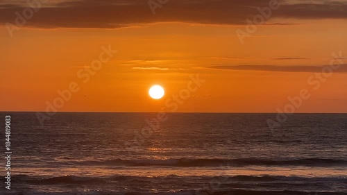 Vivid orange sunset low over the ocean horizon