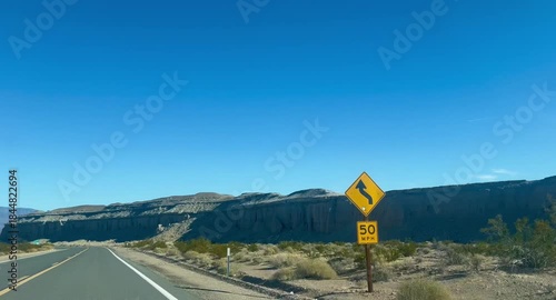 POV driving down rural highway with mountain landscape