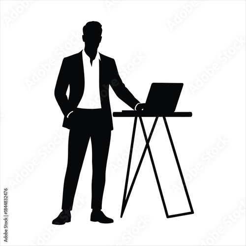 Silhouette of a businessman standing next to a laptop on a table