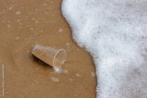 Plastic Waste Scattered on Beach Sand. Plastic waste on beaches is a serious global problem.