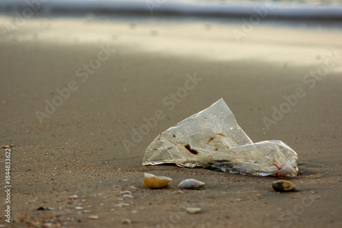 Plastic Waste Scattered on Beach Sand. Plastic waste on beaches is a serious global problem.