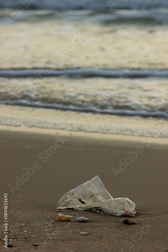 Plastic Waste Scattered on Beach Sand. Plastic waste on beaches is a serious global problem.