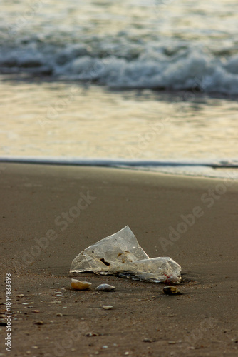 Plastic Waste Scattered on Beach Sand. Plastic waste on beaches is a serious global problem.