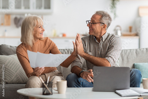 Foto An older couple shares a joyful moment at home discussing plans