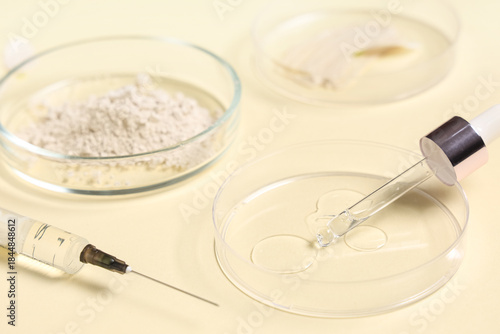 Petri dishes with different samples and laboratory equipment on beige background