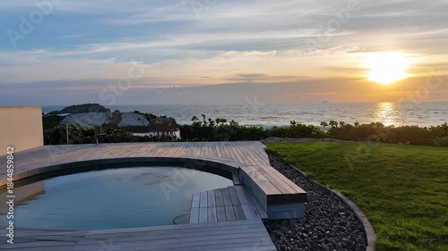Tranquil Exterior Scene of a Circular Pool at Sunset with the Sea and Sky Horizon