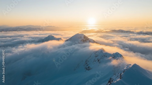 Snow-capped mountain peaks rising above a sea of clouds at sunrise