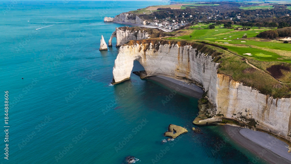 Fototapeta premium Aerial drone view of picturesque coastal limestone cliffs and the English Channel town of Etretat, France