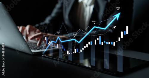 Cuadro en lienzo A business professional works on a laptop, analyzing financial data with emerging graphs to illustrate growth