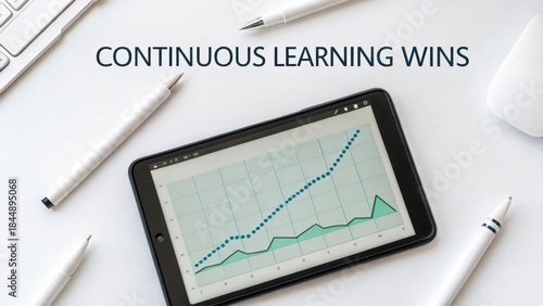 Tablet displaying a constantly updating graph of business growth and data analysis on a white surface with pens