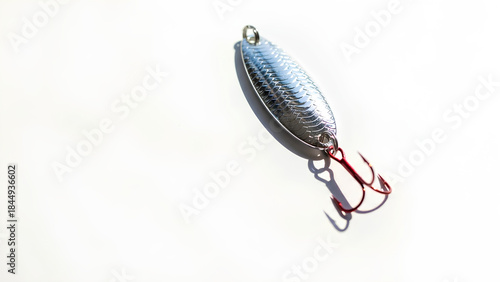 Shiny silver fishing spoon lure with red treble hook for freshwater and saltwater angling