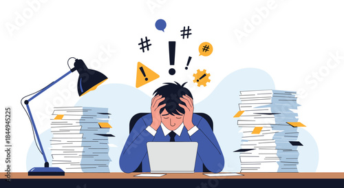 Overwhelmed and stressed businessman at his desk holding his head in despair, surrounded by huge stacks of paperwork and a laptop.