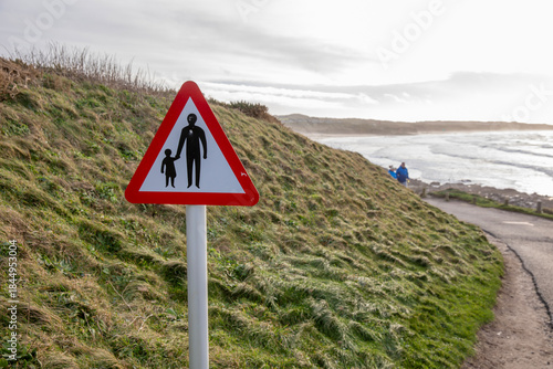 A pedestrian warning sign at Godrevy Beach in Cornwall, UK.