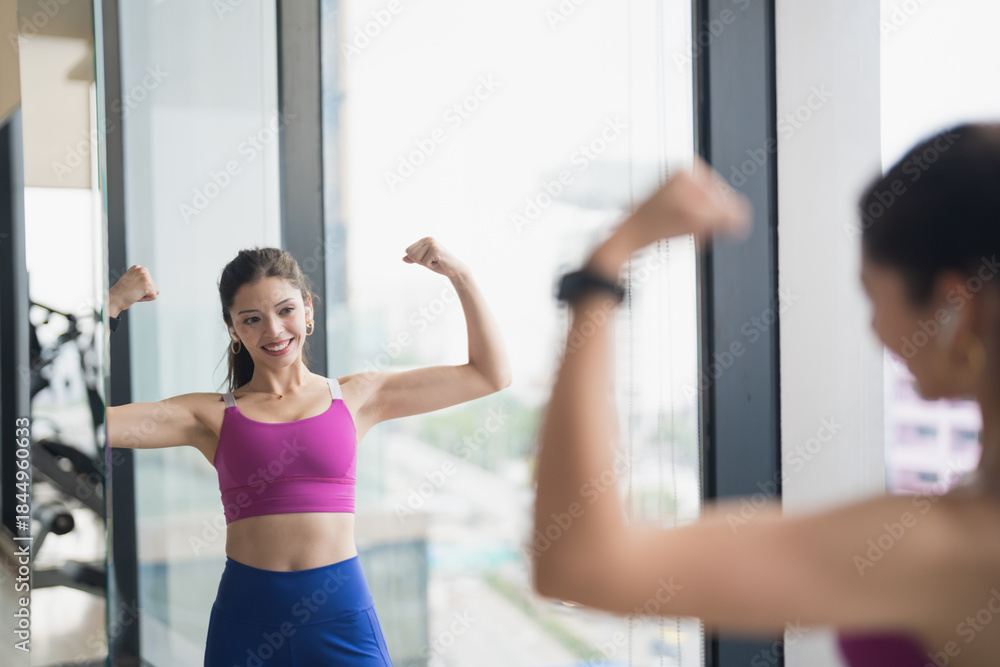 Fototapeta premium Healthy Young Hispanic Gen Z Woman in Sportswear Shaping Body for Confidence and Weight Loss at Gym.