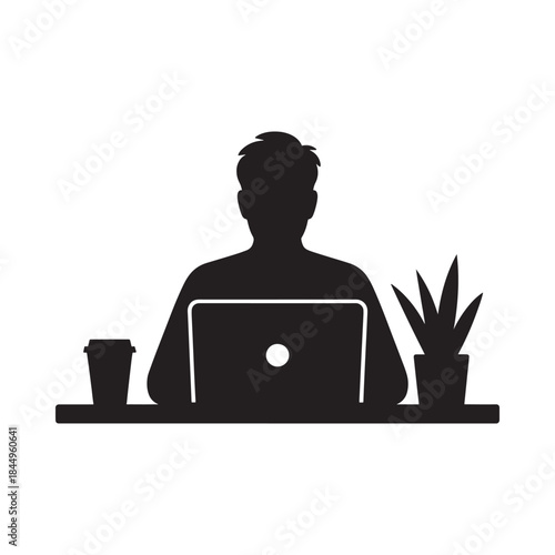 A silhouetted figure working on a laptop with a plant and drink nearby