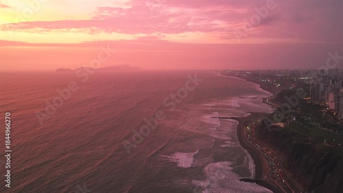 Wallpaper Mural Afterglow sunset Miraflores coastal seaside aerial drone harbor Lima Peru cars traffic Makaha Barranco beach pink purple clear skies hazy cityscape skyscraper buildings ocean waves static shot Torontodigital.ca