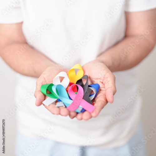 World cancer day, February 4. Elderly with colorful ribbons, blue, yellow, red, green, white, pink and grey for supporting people living and illness. Health, Medical, awareness and Insurance concept