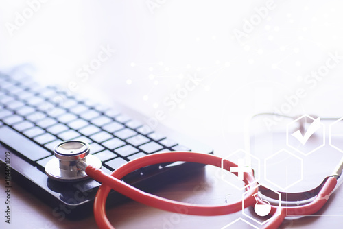 Stethoscope, test tubes, laptop, prescriptions, glasses on the table. Doctor`s desk in the clinic's office.