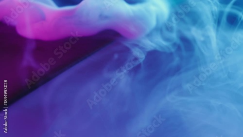 Liquid smoke. Neon paint cascade. Defocused blue purple color glass fume texture vapor splash spill on abstract underwater background.