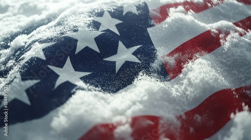 A snow-covered American flag with stars and stripes, partially buried in snow, with a blurred background.
