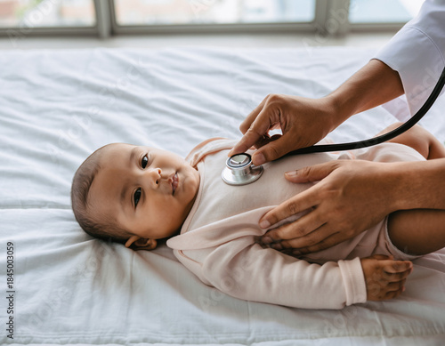 Caring Male Pediatrician Gently Examining a Healthy Baby During Medical Checkup in a Bright Modern Hospital Room, Showing Professional Healthcare, Child Care, and Trust Between Doctor and Infant