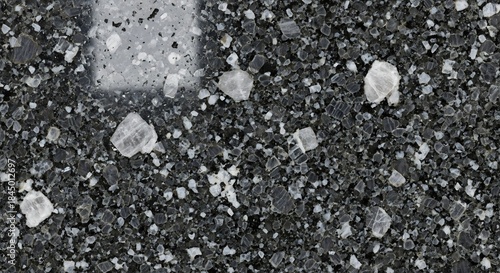 Close-up of a dark, textured surface with scattered, crystalline particles, creating a unique pattern.