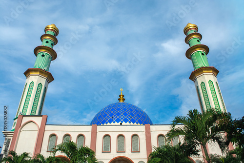 A mosque standing majestically against a beautiful blue cloud background