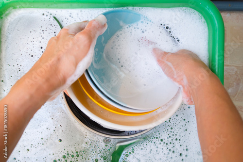 Washing dishes in the kitchen. Close-up of female hands