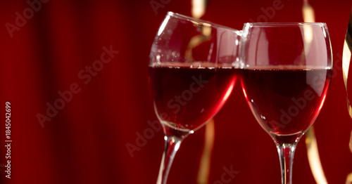 Two red wine glasses against a burgundy bokeh background, studio shot. Background for celebrations, wedding dinners, New Year's, Valentine's Day, and dating 