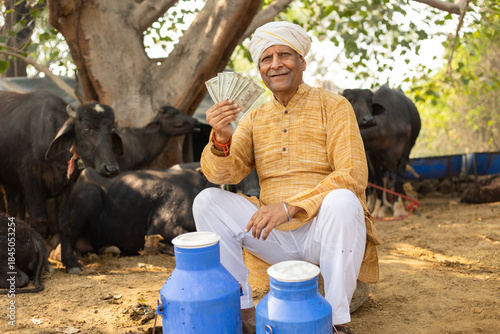 Happy Rural indian dairy farmer holding money, earning and profits, Cattle Farming industry, Successful cow milk business. India economy