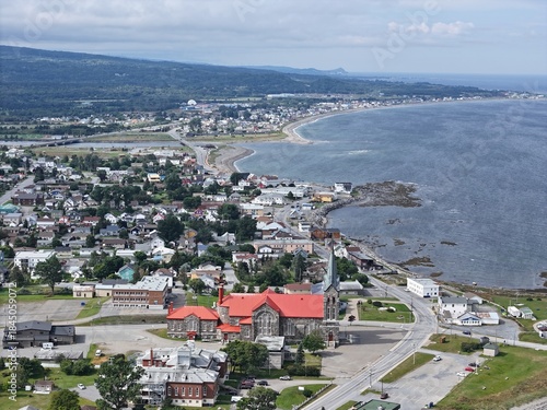Tableau sur toile Aerial view of St Ann Catholic Church near Sainte Anne des Monts in Quebec town with houses and mountains